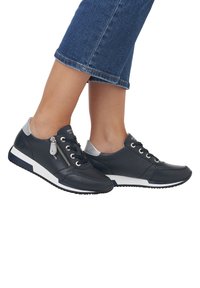 Dunkelblaue Ledersneaker mit grauen Akzenten, ausgestattet mit einem Reißverschlussdetail, weißen Sohlen und schwarzen strukturierten Gummisohlen.