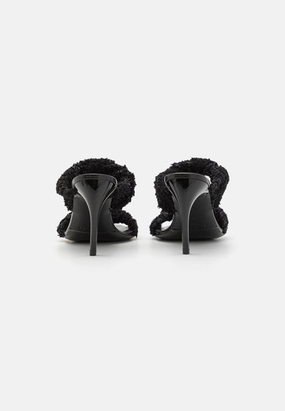 Sorte højhælede sandaler med bløde, teksturerede remme og en glat, blank hæl. Åbent bagdesign med en minimalistisk stil.