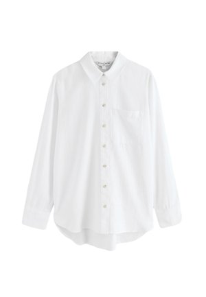 Cămașă albă cu mâneci lungi, nasturi, guler și buzunar la piept, tiv ușor curbat și nasturi asemănători cu perle pe un fundal simplu.