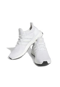 Vita träningsskor med ett andningsbart stickat överdel, med tre vita ränder, en texturerad sula och en svart yttersula som accent.