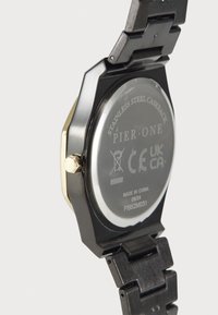 Montre octogonale avec un bracelet en acier inoxydable noir et des accents dorés. Dispose d'un fond de boîtier transparent avec des détails gravés et des marquages.