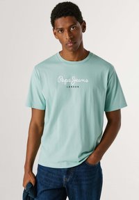 Ανοιχτό μπλε βαμβακερό T-shirt με στρογγυλή λαιμόκοψη και κοντά μανίκια, με εκτύπωση "Pepe Jeans" και "LONDON" σε λευκό και μαύρο.