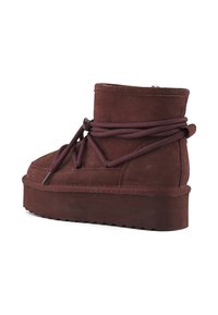Stivaletti in suede bordeaux con suola a piattaforma texturizzata, caratterizzati da spesse stringhe avvolte attorno al corpo per una vestibilità sicura.