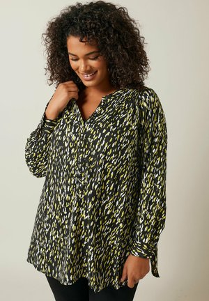 Blusa a maniche lunghe con motivo nero, giallo e bianco, con chiusura a bottoni sul davanti e taglio morbido, realizzata in un tessuto liscio.