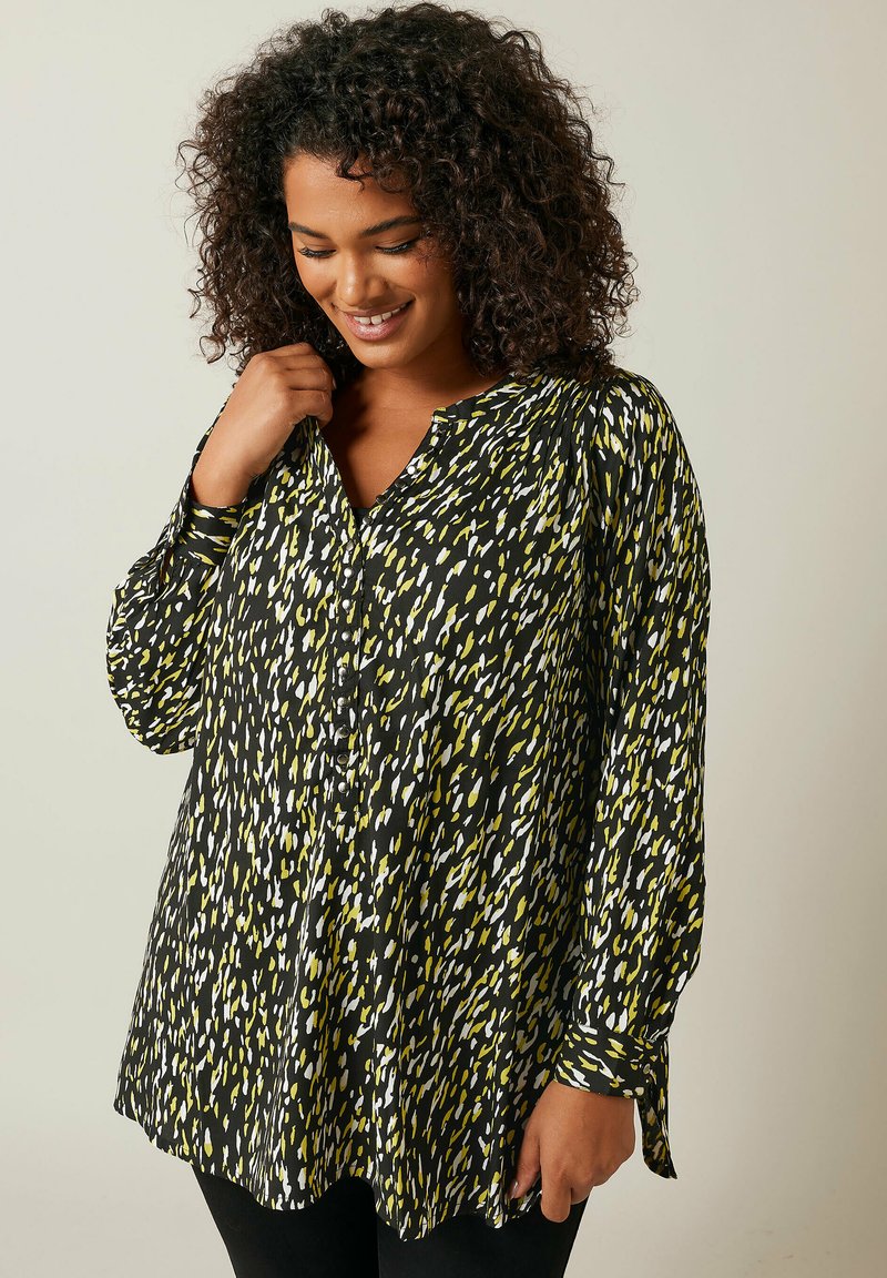Blusa a maniche lunghe con motivo nero, giallo e bianco, con chiusura a bottoni sul davanti e taglio morbido, realizzata in un tessuto liscio.