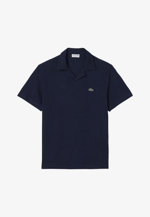 Laivaston sininen lyhythihainen poolopaita, jossa on avonainen kaulus ja pieni vihreä krokotiililogo vasemmassa rinnassa.