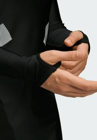 Sort langærmet beklædningsgenstand med tætsiddende manchetter; har diagonale hvide striber på brystet, glat tekstur og en tætsiddende pasform for komfort.