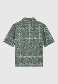 Korte mouw shirt in lichtgroene stof met een geometrisch bladerenpatroon in donkerder groen. Voorzien van een kraag en een relaxte pasvorm.