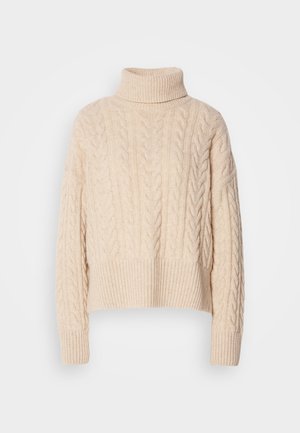 Pulover cu guler înalt din tricotare cu cablu, de culoare crem, cu manșete și tiv cu dungi. Textură din lână groasă, design scurt și croială lejeră.