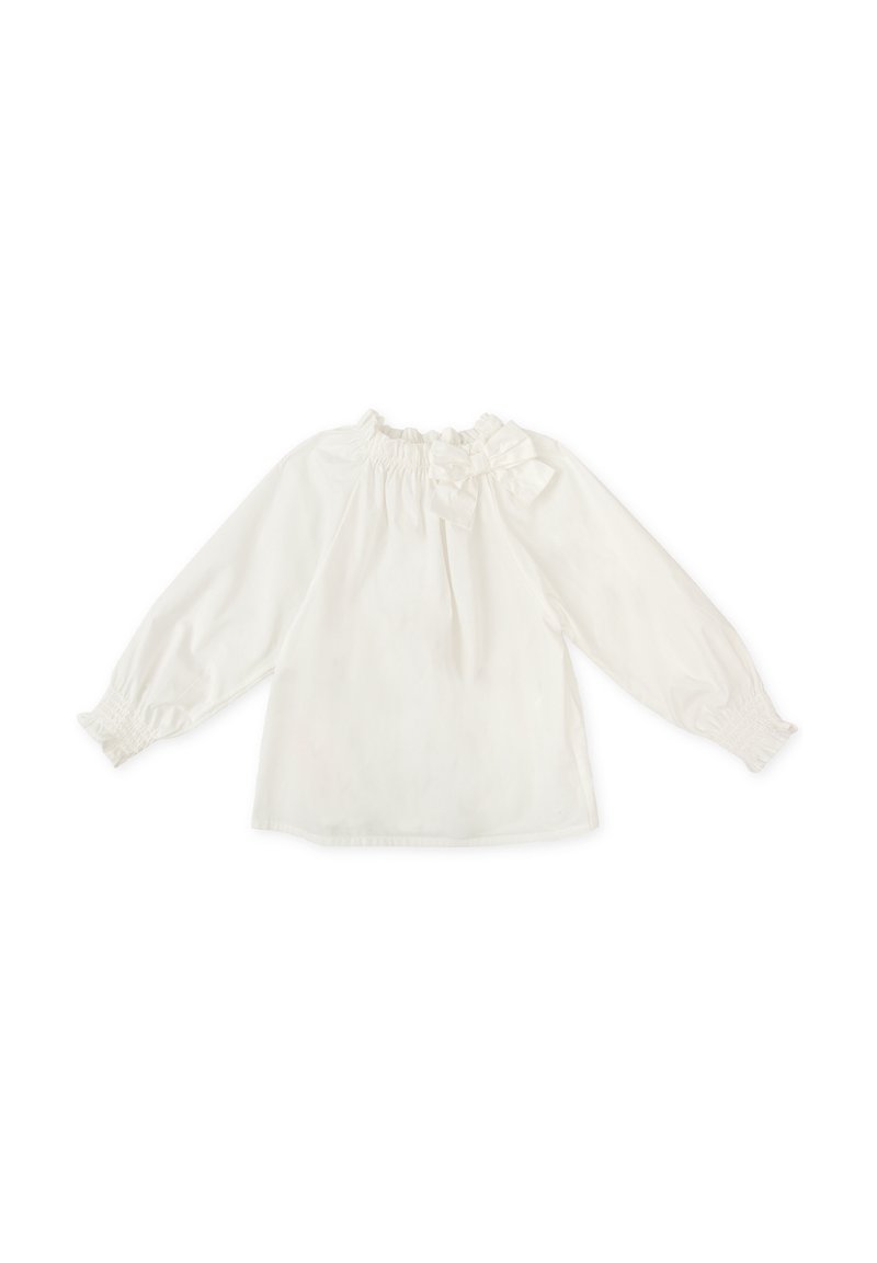 Blusa blanca de manga larga con un escote volante y detalle de moño en el hombro. Tejido suave con puños elásticos y corte holgado.