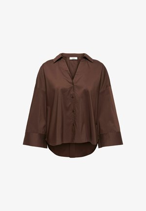 Blouse marron à manches longues avec boutons, poignets larges, col et ourlet légèrement arrondi, présentée sur un fond blanc.