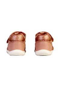 Sneakers per bambini rosa con retro testurizzato, dettagli brillanti, un cinturino a strappo e una suola in gomma bianca.