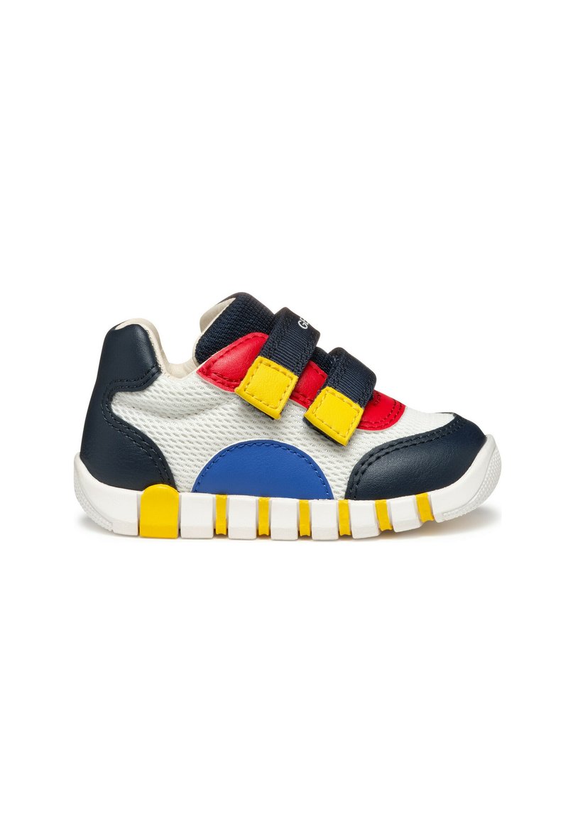 Chaussure multicolore avec un corps en mesh blanc, des accents en cuir bleu et rouge, un talon bleu marine, une sangle jaune et une semelle en caoutchouc avec une texture antidérapante.