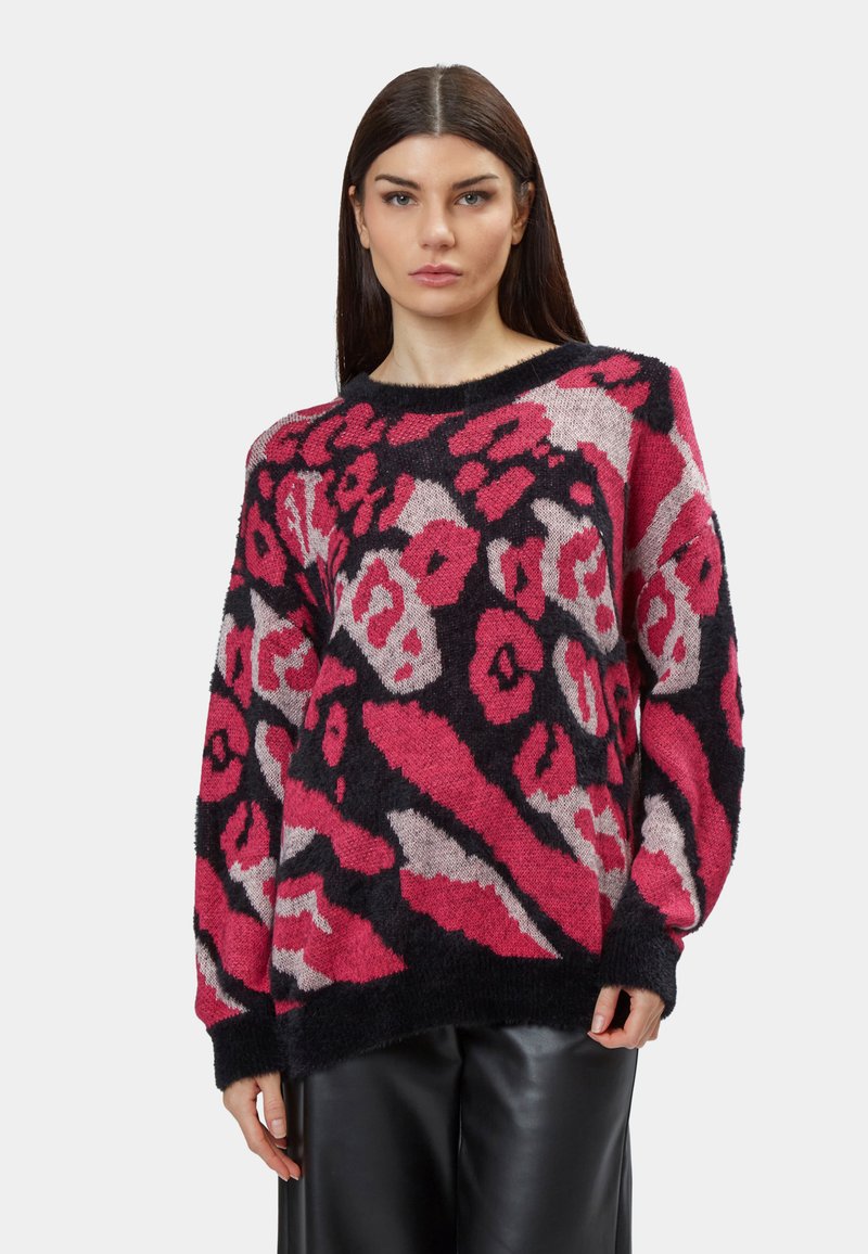 Strickpullover mit einem auffälligen pinken und schwarzen abstrakten Muster, Rundhalsausschnitt und lockerer Passform mit langen Ärmeln und strukturiertem Stoff.