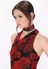 Rotes Blumendruckkleid mit Halterneck-Design. Hergestellt aus leichtem Stoff, verfügt es über einen schwarzen Hintergrund und eine subtile Textur.