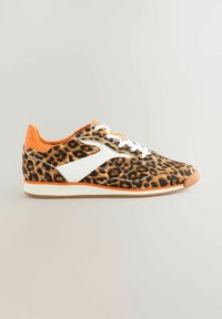 Sneaker mit Leopardenmuster, weißen Akzenten und orangefarbenem Fersenbereich. Verfügt über weiße Schnürsenkel und ein strukturiertes Obermaterial, das auf einer Gummisohle sitzt.