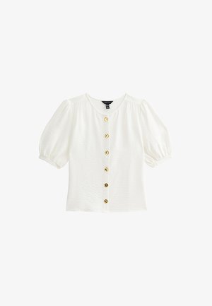 Blusa blanca de manga corta con tejido texturizado, escote redondo y siete botones dorados a lo largo del frente. Manga ligeramente abullonada.