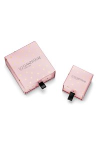 Dve roza kartonske darilne škatle z zlatimi vzorci srca. Večja škatla ima črn potegni tab in obe sta opremljeni z blagovno znamko "GLANZSTÜCKE MÜNCHEN."