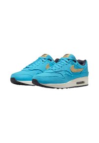 Turquoise Nike Air Max sneakers with a ribbed texture, gold accents, black outsole, and a visible air unit in the midsole.