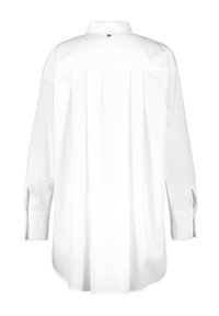 Chemise blanche à manches longues avec un pli dans le dos, un col boutonné et des fentes sur les poignets. Tissu en coton lisse avec un design minimaliste.