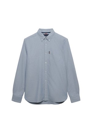 Lyseblå skjorte med lange ærmer, knaplukning, knapper på kraven og brystlomme på hvid baggrund.