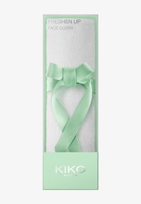 Paño blanco con superficie texturizada, envuelto con una cinta verde claro atada en un lazo, etiquetado como "REFRESCAR" por KIKO Milano.