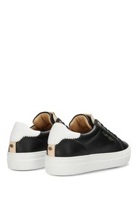 Czarne skórzane trampki z białym falowanym obcasem, beżowymi akcentami, okrągłym czubkiem i płaską białą gumową podeszwą. Z przodu sznurowane z złotymi elementami.