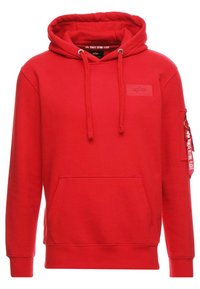 Felpa rossa con cappuccio in misto cotone, dotata di tasca anteriore a marsupio, cappuccio con cordini, polsini a coste e tasca laterale con zip e dettaglio del tag.