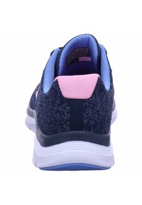 Zapatilla atlética de punto en color navy con un acabado texturizado, forro interior azul, acento en el talón rosa y suela blanca ligera, diseñada para brindar comodidad.