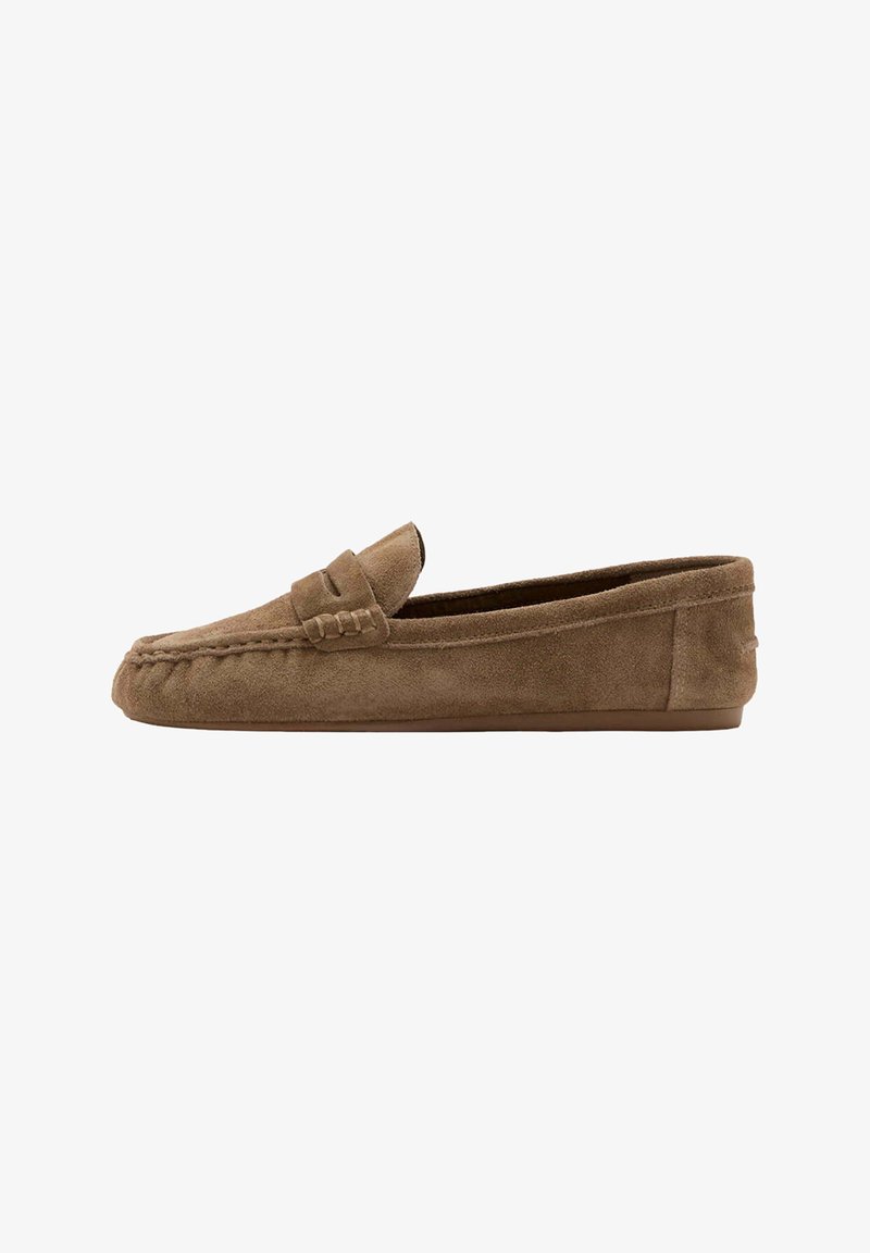 Mocassin en daim marron avec détails de coutures, petit talon et bride sur le dessus, montré de profil sur fond blanc.