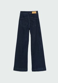 Jean bleu marine à jambes larges avec deux poches arrière et un patch en cuir beige sur la ceinture.