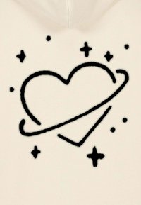 Felpa crema con un design di cuore nero circondato da un anello, con stelle e punti, su un tessuto morbido.