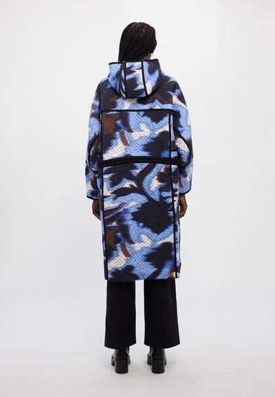 Κουβερτίνα μπουφάν σε μπλε και καφέ παραλλαγή, με κουκούλα, μακριά μανίκια και χαλαρή εφαρμογή, με αντίθετες μαύρες ραφές και λεπτομέρειες.