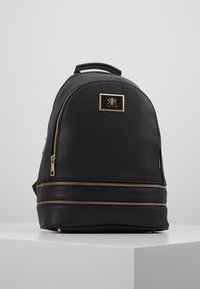 Czarny plecak o fakturze przypominającej kamyki, zaokrąglony kształt, złote akcenty metalowe, podwójne zamki błyskawiczne oraz płytka z logo z przodu.