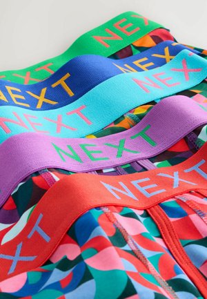 Colorful men's briefs featuring elastic waistbands in green, blue, purple, and red with "NEXT" logo in contrasting colors. Geometric patterns present.