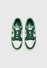 Grønne og hvide Nike sneakers med ruskind og mesh-materialer, rund tå, perforerede detaljer og teksturerede snørebånd.