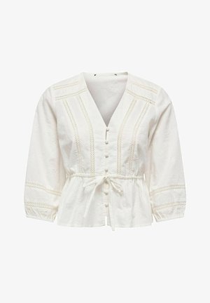 Blouse en coton blanc avec un col en V, un devant à boutons, une taille froncée avec un lien, et un riche détail brodé le long des manches et du corsage.