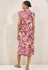 Kurzärmeliges Kleid mit einem rosa, cremefarbenen und schwarzen Tigerstreifenmuster, in der Taille mit einem Band gerafft, aus leichtem Stoff gefertigt.