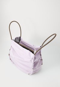 Paarse stoffen draagtas met twee gevlochten handvaten. Heeft een zachte, geplooide vormgeving en een binnenzak met rits. Soepele textuur, minimale hardware.