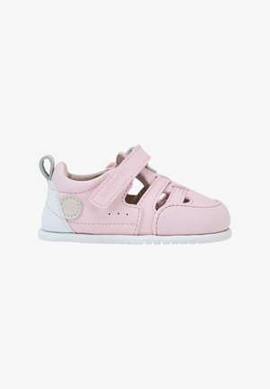 Zapatos infantiles de cuero rosa con diseño perforado, correa ajustable, suela blanca y logotipo de marca. Presentan un acabado texturizado y acentos.