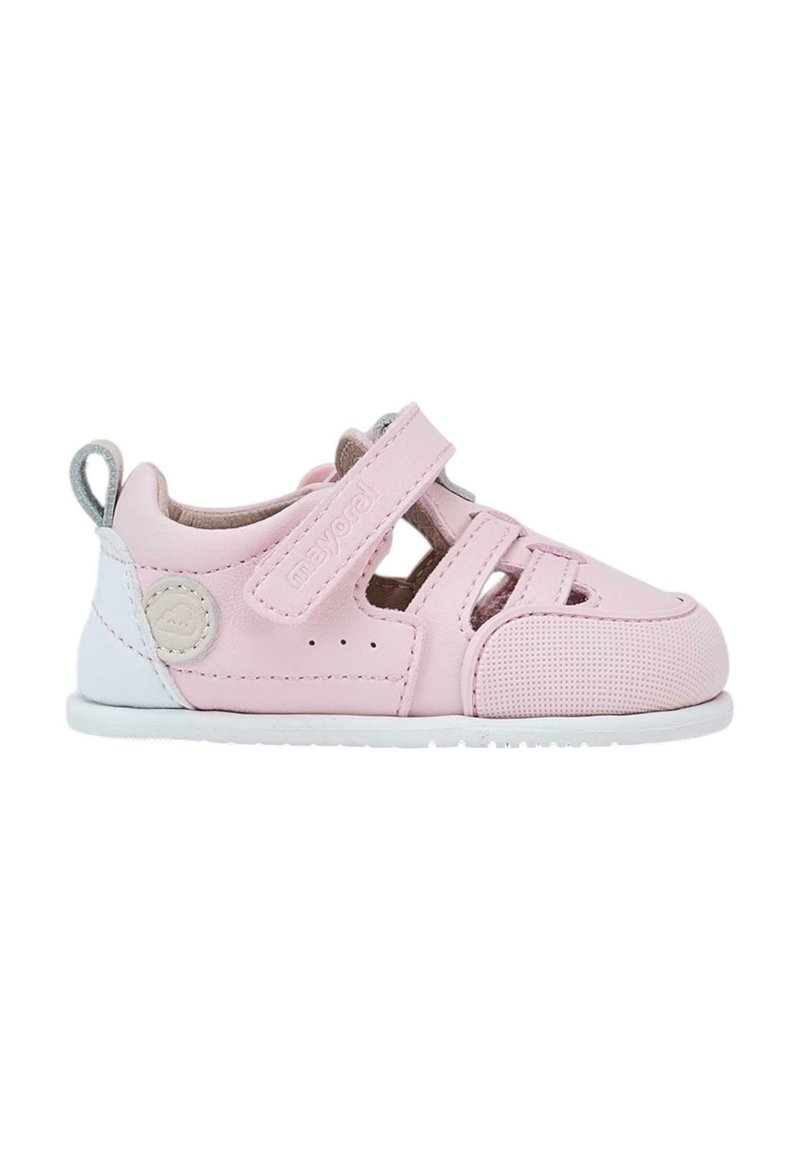 Zapatos infantiles de cuero rosa con diseño perforado, correa ajustable, suela blanca y logotipo de marca. Presentan un acabado texturizado y acentos.