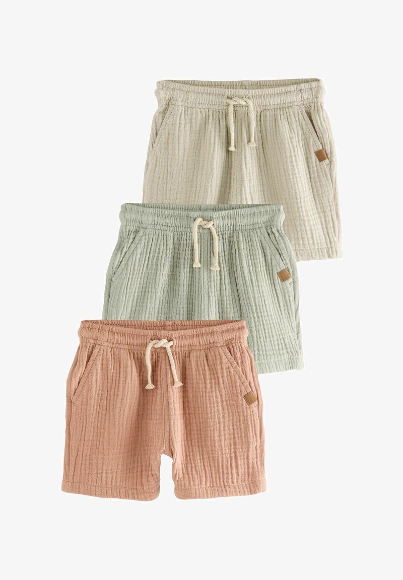 Three pairs of textured cotton shorts in cream, light green, and dusty pink, each with an elastic waistband, drawstring, and side pockets.