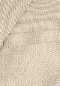 Beige strukturierter Stoff mit einem gewebten Muster, das kleine abwechselnd helle und dunkle Fäden aufweist. Enthält ein dekoratives Taschendetail.