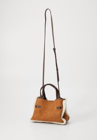 Petit sac à main en daim marron avec des finitions en fourrure blanche, deux petites poignées et une longue bandoulière ajustable marron foncé.