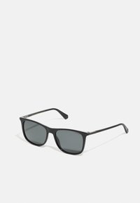 Ochelari de soare negri cu ramă pătrată, lentile gri și finisaj mat. Prezintă un design simplu cu un branding subtil pe tâmple.