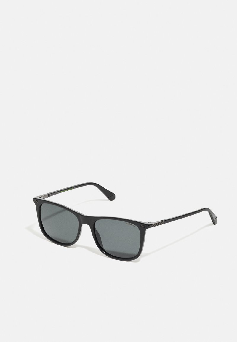 Ochelari de soare negri cu ramă pătrată, lentile gri și finisaj mat. Prezintă un design simplu cu un branding subtil pe tâmple.