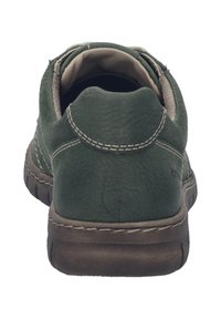 Zielone skórzane trampki o teksturowanej powierzchni, z wyściółką wokół kostki i delikatnym przeszyciem. Posiadają gumową podeszwę, która zapewnia przyczepność i elastyczność.