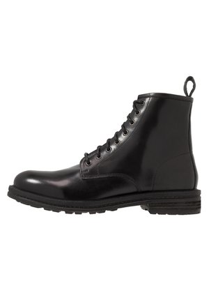 Black leather ankle boot with a rounded toe, side lacing, six eyelets, and textured rubber sole. Features a pull tab on the heel.
