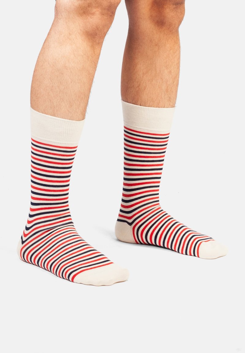 Baumwollsocken mit horizontalen Streifen in Rot, Marineblau und Creme. Gerippter Bund, knöchellange Ausführung und glatte Textur auf dem Fuß.