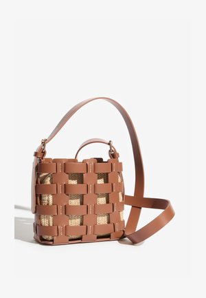 Braune, geflochtene Ledertasche mit einem beigen, gestrickten Innenbeutel, ausgestattet mit zwei Trägern: einem kurzen Griff und einem langen, verstellbaren Schulterriemen.